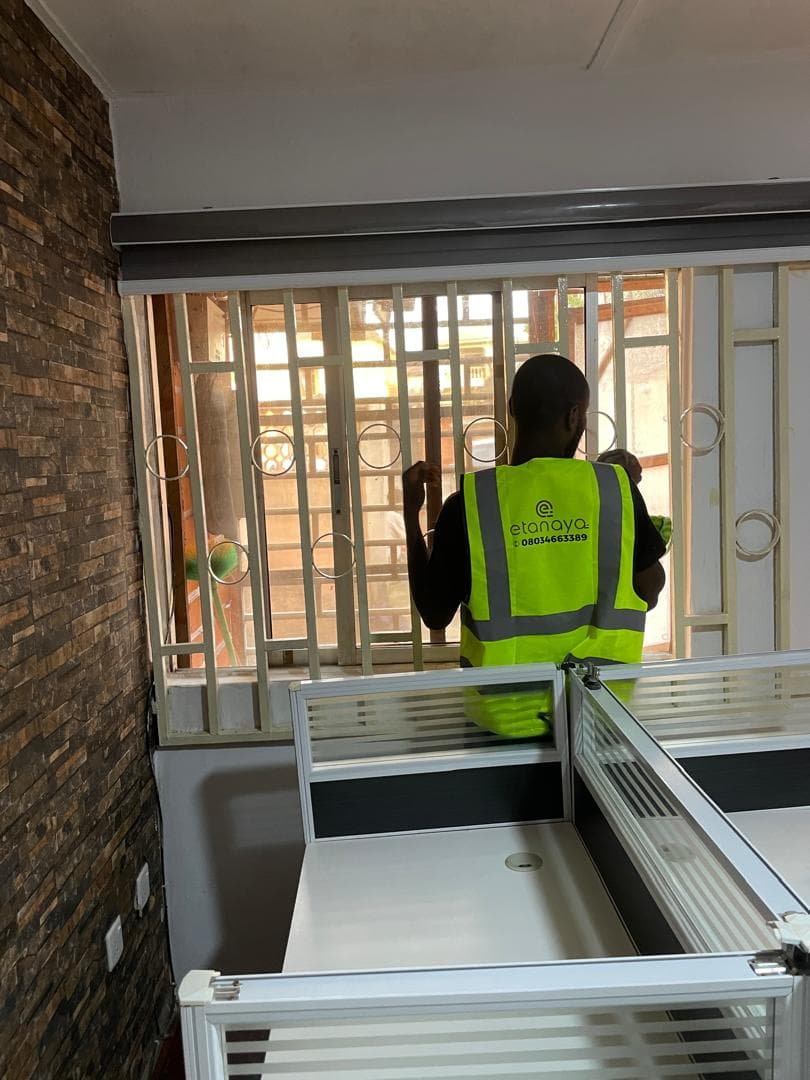 Etanaya operative cleaning windows in a commercial office workspace