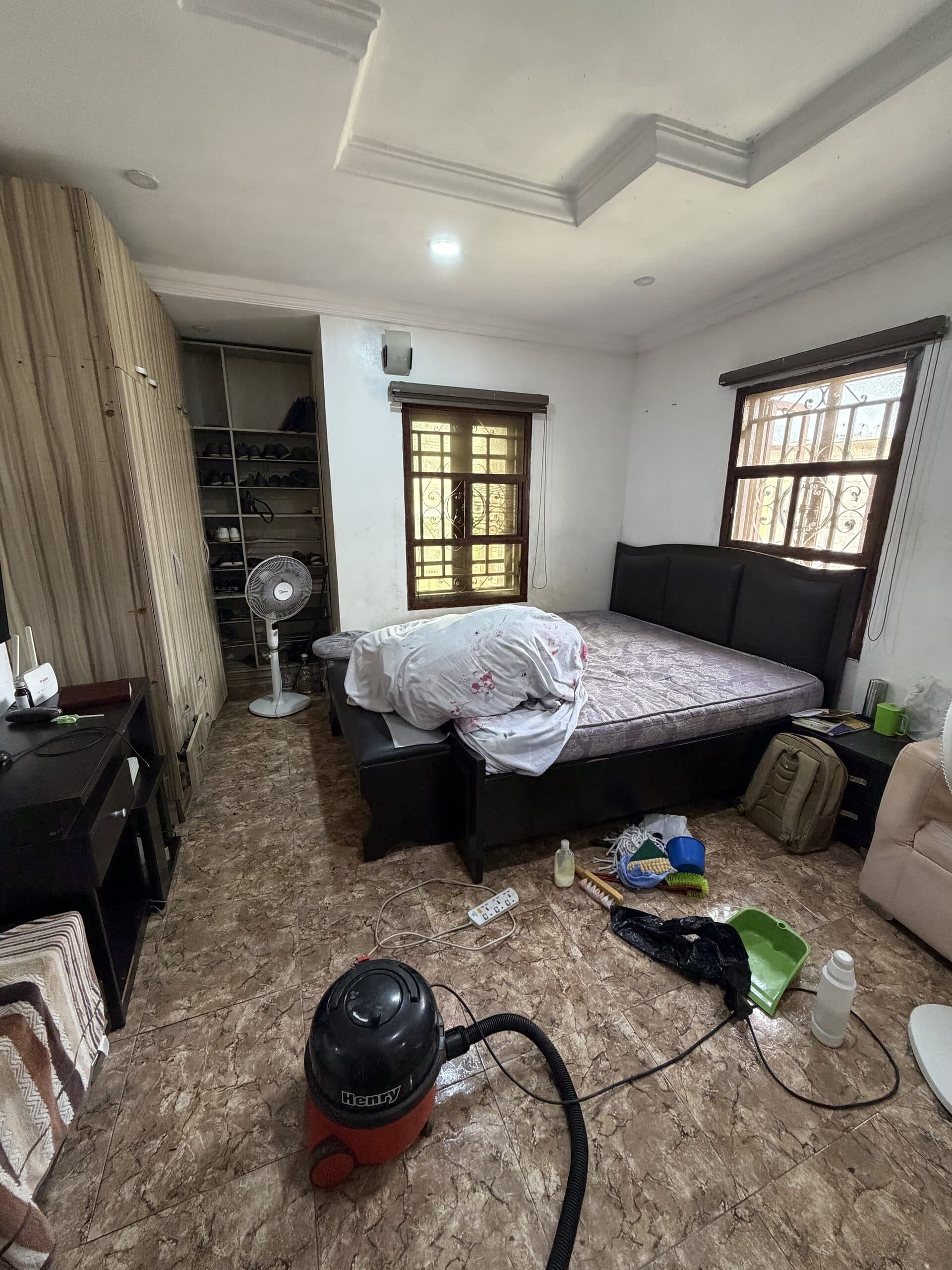 Bedroom with Etanaya vacuum and cleaning supplies laid out on the floor