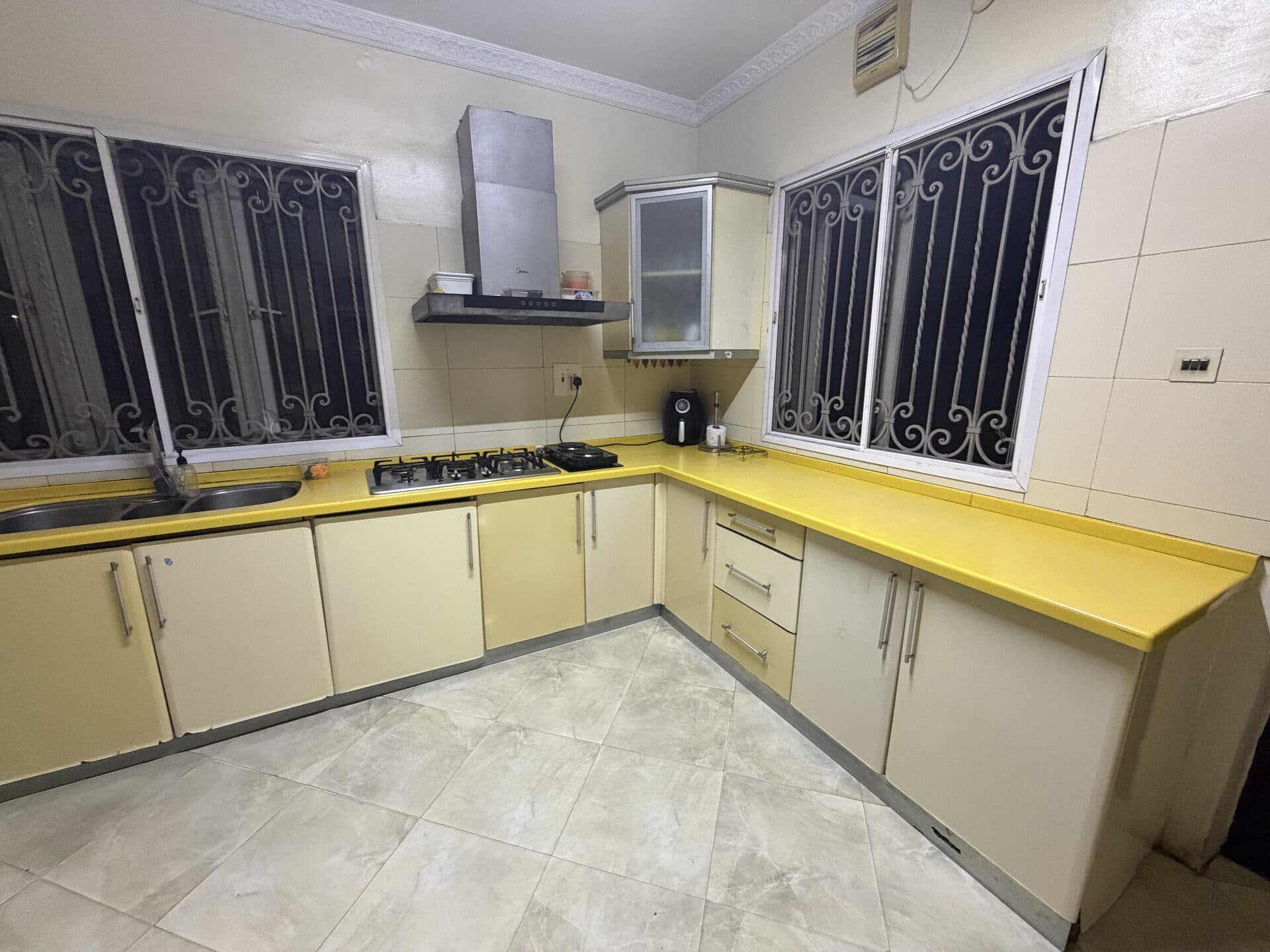Finished kitchen with clear yellow countertops and clean tiled floor