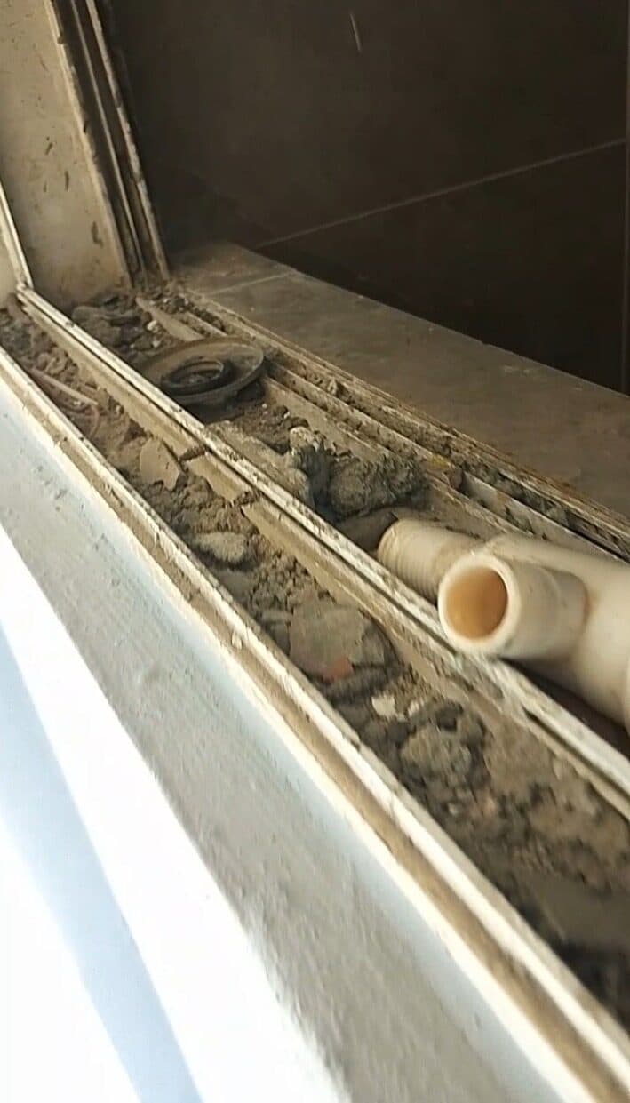 Window track packed with construction debris and dust before cleaning